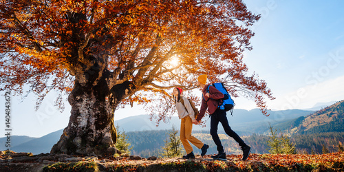 Couple of young tourists are walking in the mountain forest. Beautiful mountain panorama landscape background.