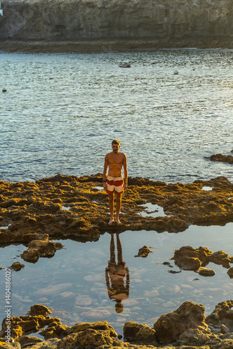 Obraz na płótnie Tourist reflecting on volcanic rocks at tufia beach, gran canaria w salonie