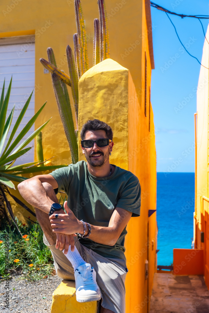 Tourist relaxing in colorful puerto de mogan, gran canaria