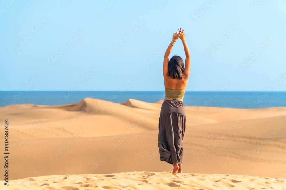 Tourist raising arms in maspalomas dunes, gran canaria, spain