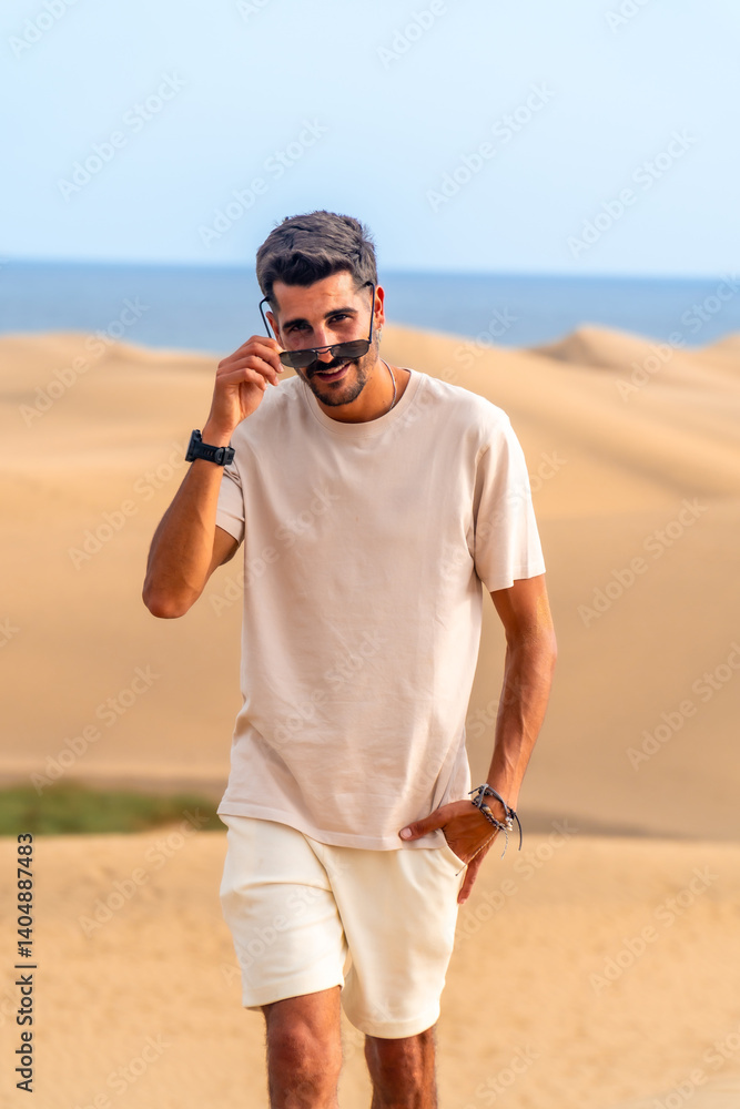 Tourist lowering sunglasses walking on maspalomas dunes in gran canaria