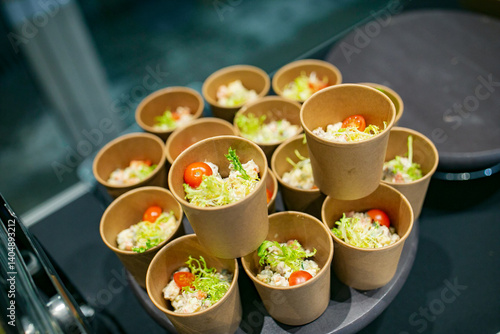 On a welldecorated table, there is a large tray adorned with numerous cups, each filled with delicious food, ready to be enjoyed