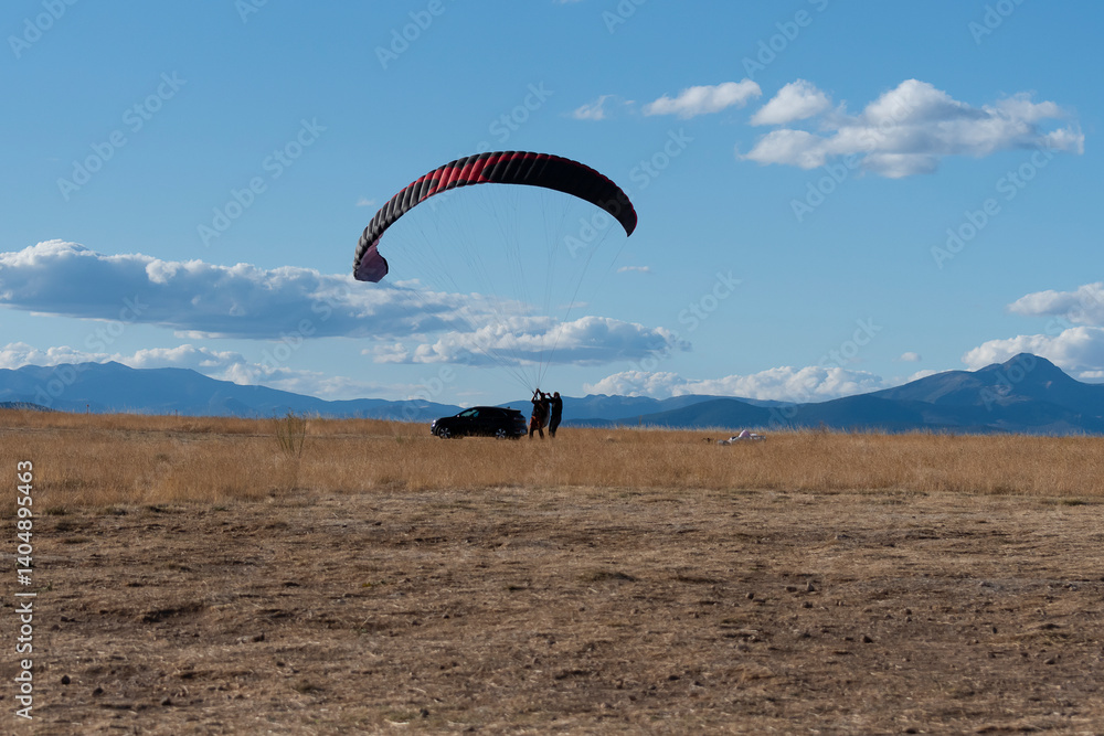 Paragliding adventure in open landscape with mountains and clear blue sky Paragliding adventure in open landscape with mountains and clear blue sky