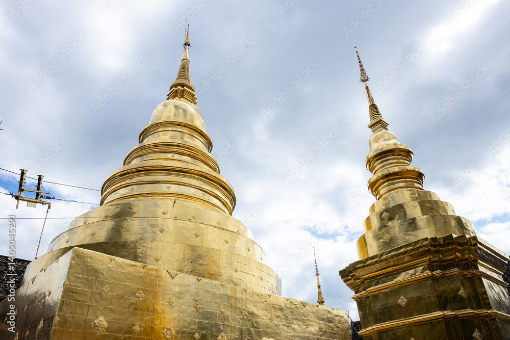 Fototapeta premium Golden pagodas at Thai temple under cloudy sky