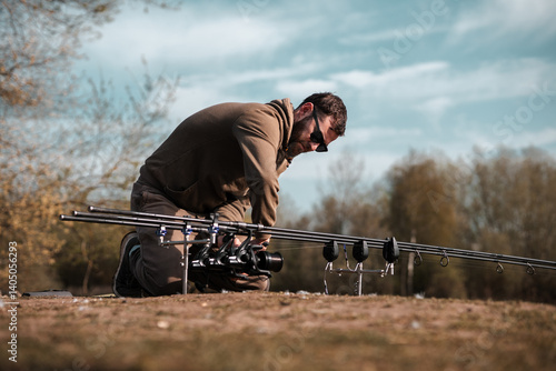 Konstfotografi Fishing scene, carp fisherman on a lake angling with rods