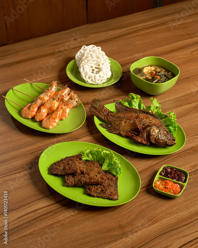 Traditional Sundanese Meal Set with Fried Fish, beef jerky, Shrimp Skewers, Boiled Vegetables, Sambal, and Assorted Side Dishes.