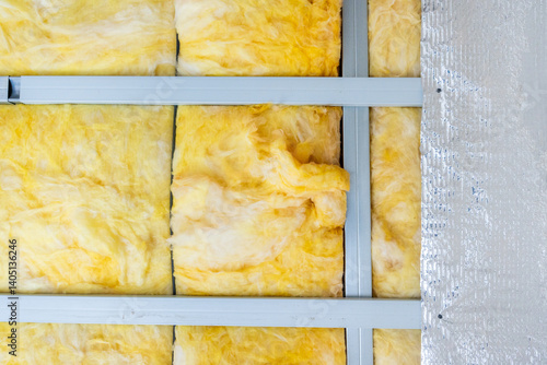 Billede på lærred Yellow glass wool insulation material between metal profiles providing thermal i