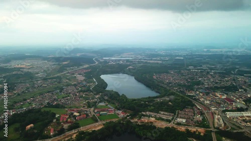 Aerial view of a large lake surrounded by residential and urban areas. Captured by drone from high altitude. Suitable for environment, landscape, and urban development projects.