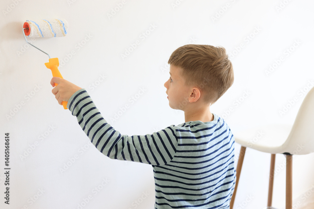 A young boy renovating a room, sanding the walls with sandpaper and painting them white with a roller. Home improvement and DIY repair concept A young boy renovating a room, sanding the walls with sandpaper and painting them white with a roller. Home improvement and DIY repair concept