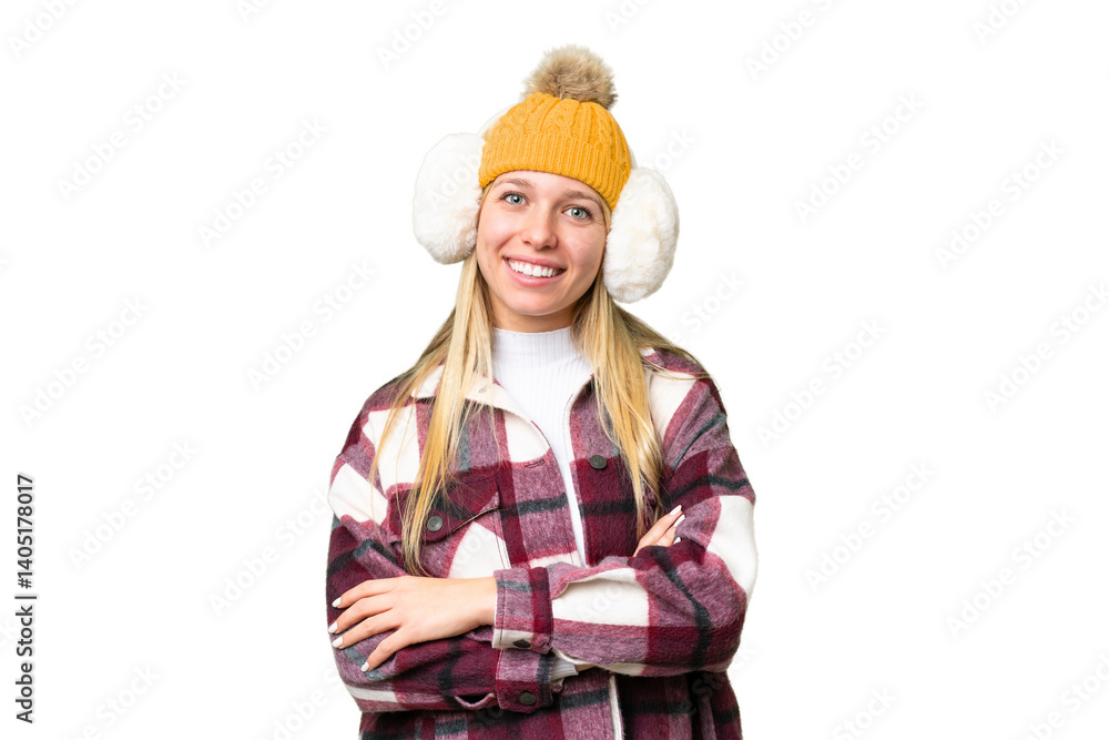 Young pretty blonde woman wearing winter muffs over isolated chroma key background keeping the arms crossed in frontal position Young pretty blonde woman wearing winter muffs over isolated chroma key background keeping the arms crossed in frontal position