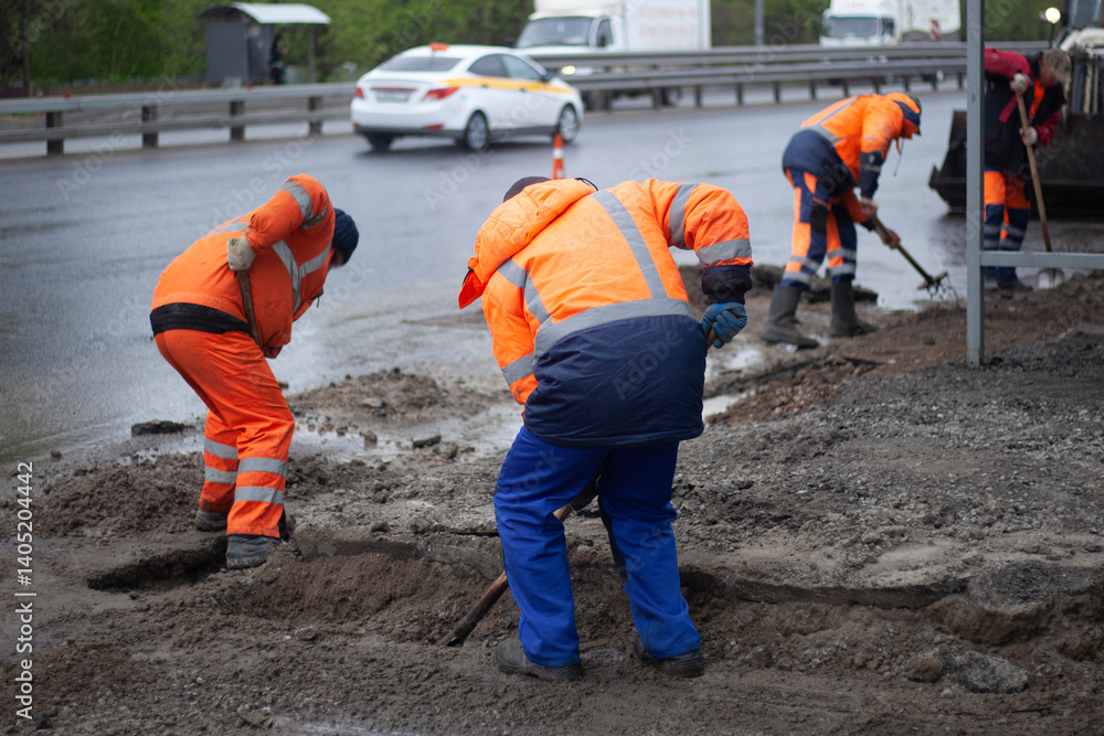 Laying asphalt on road. Repair of road. Worker with shovel.