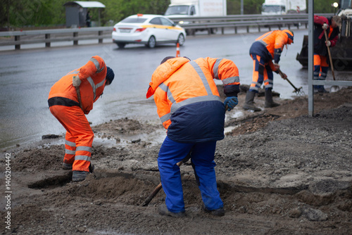 Obraz na płótnie Laying asphalt on road. Repair of road. Worker with shovel. w salonie
