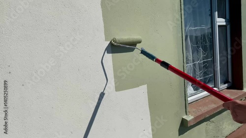 Exterior house painting in progress with ladders and tools visible. A clean and organized workspace under clear skies shows a home improvement project in a calm neighborhood.