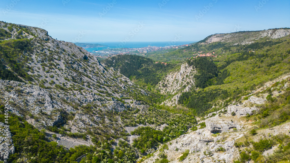 Naklejka premium Aerial view of the Giordano Cottur cycle and pedestrian path near Trieste, Italy, winding through the stunning Val Rosandra Nature Reserve. This scenic trail follows a dramatic canyon, panorama