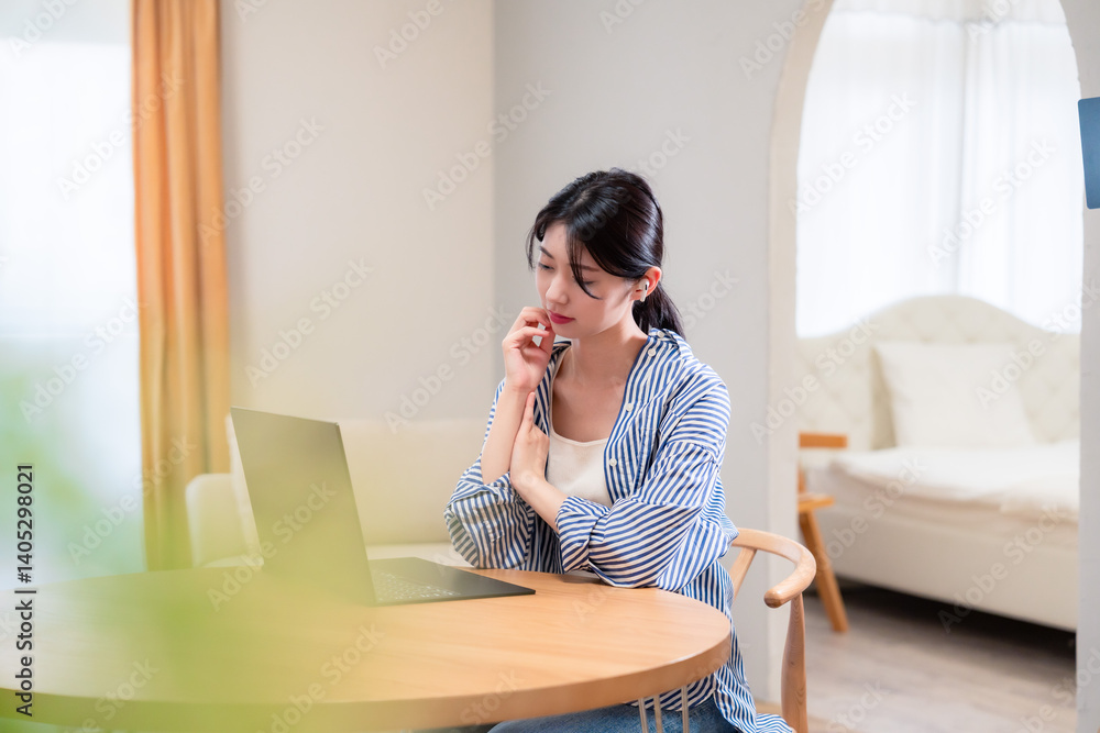 在宅勤務をしながら頭を抱える若い女性 在宅勤務をしながら頭を抱える若い女性