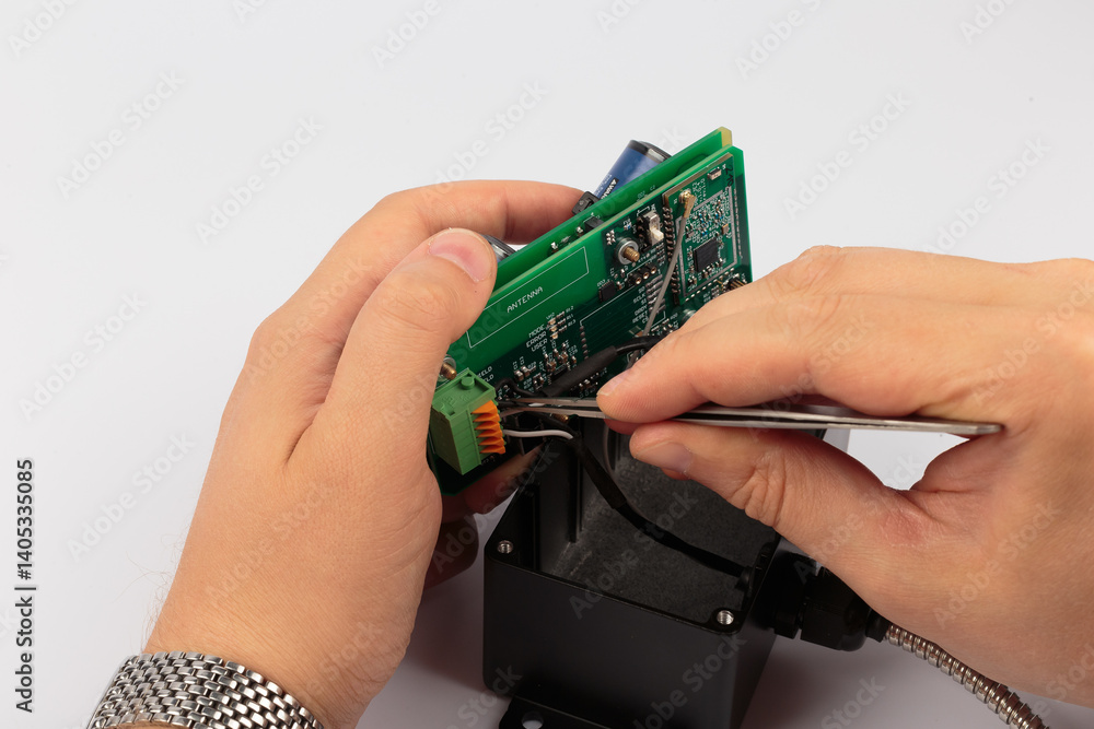 Hands of a master holding an electronic board on a white background