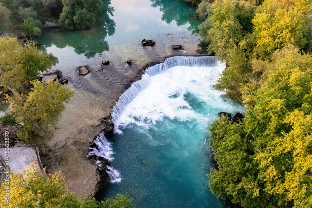 Manavgat Waterfall, Antalya. Stunning aerial view of Manavgat Waterfall with its vibrant turquoise waters and lush green vegetation. A breathtaking natural wonder from above.
