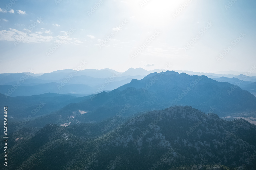 Magnificent nature with mountains and forests. Beautiful sunny valley with blue sky in summer. Aerial view with drone.