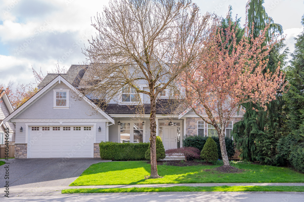 Two story stucco luxury house with nice spring blossom landscape in Vancouver, Canada, North America. Day time on April 2025. Two story stucco luxury house with nice spring blossom landscape in Vancouver, Canada, North America. Day time on April 2025.