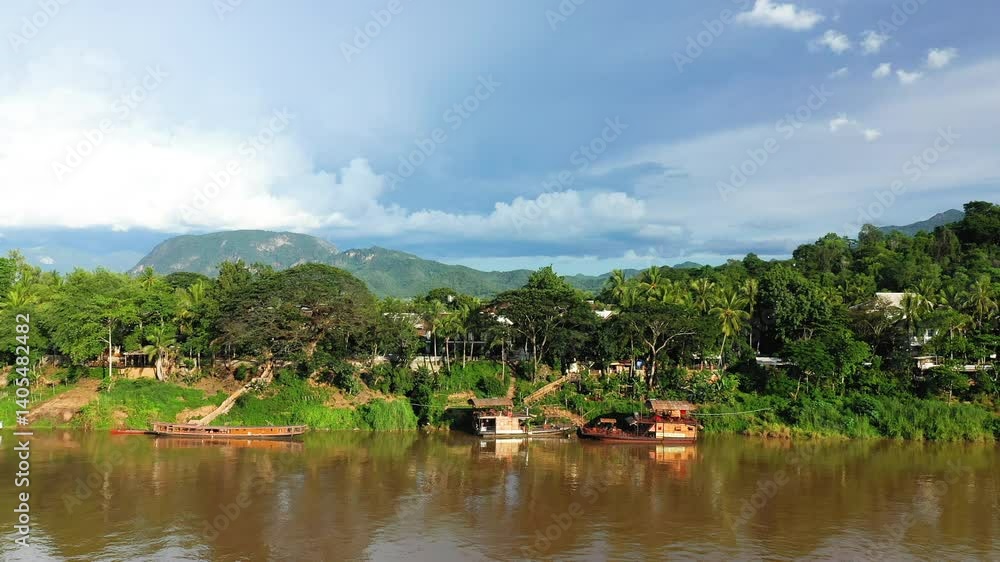 Boats moored along the Mekong River in Asia, Laos, Luang Prabang, in summer on a sunny day. Boats moored along the Mekong River in Asia, Laos, Luang Prabang, in summer on a sunny day.
