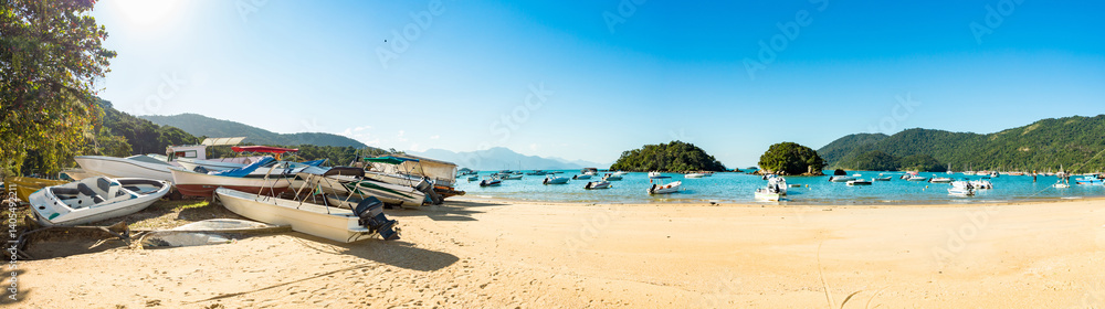 Obraz premium Panoramic blue and green beach vacation in the village of Abraao with boats on a sunny day, on the tropical island Grande, Rio de Janeiro, Brazil, South America.