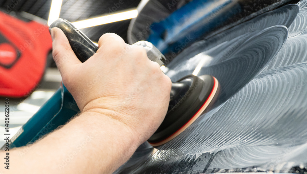Obraz premium A man polishes the glass of a car with a polishing machine from small scratches with a large one. Auto glass repair, replacement. Car detailing. Hands with an orbital polishing machine. Close-up.