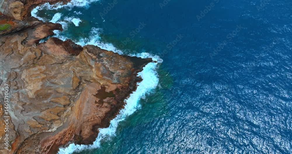 Waves splash at the rocks. Pacific Ocean at the rugged shore. Rocky coastline aerial. Waves splash at the rocks. Pacific Ocean at the rugged shore. Rocky coastline aerial.