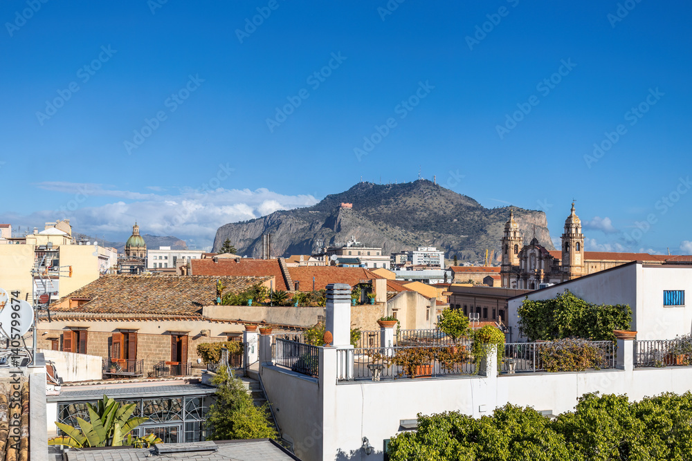 Naklejka premium Vibrant cityscape with a mix of historical and modern architecture, set against a mountainous backdrop