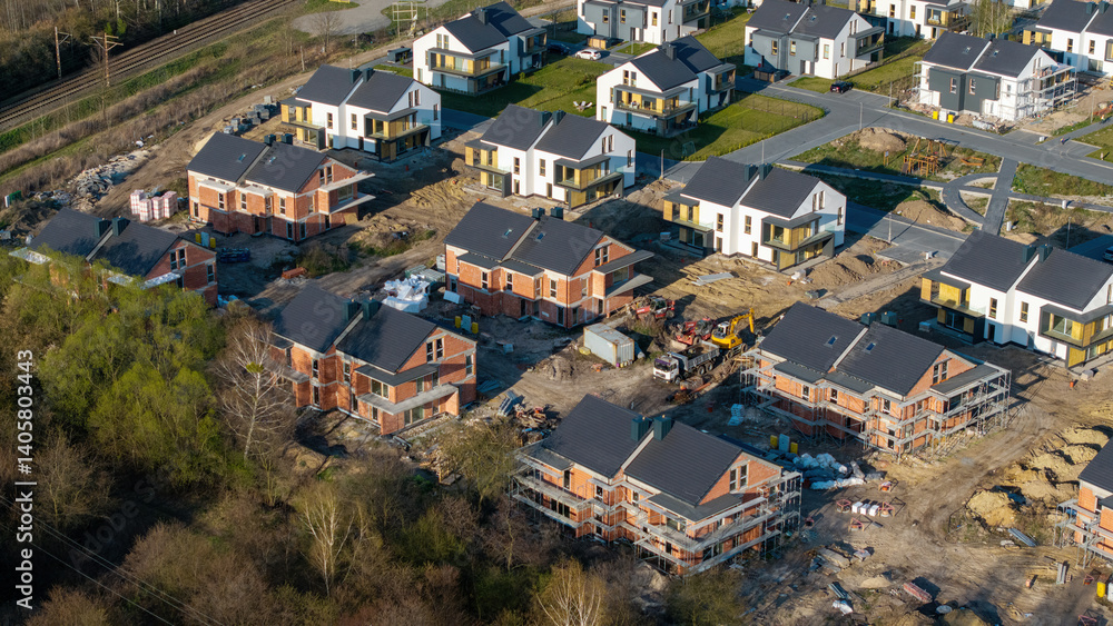 Fototapeta premium Aerial view of a new suburban housing estate in spring, featuring newly built homes, a concept representing the real estate market.