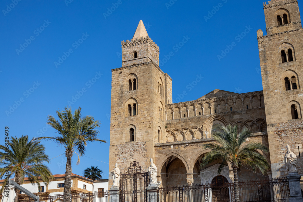 Obraz premium Yellow stone weathered сathedral with two towers and palm trees