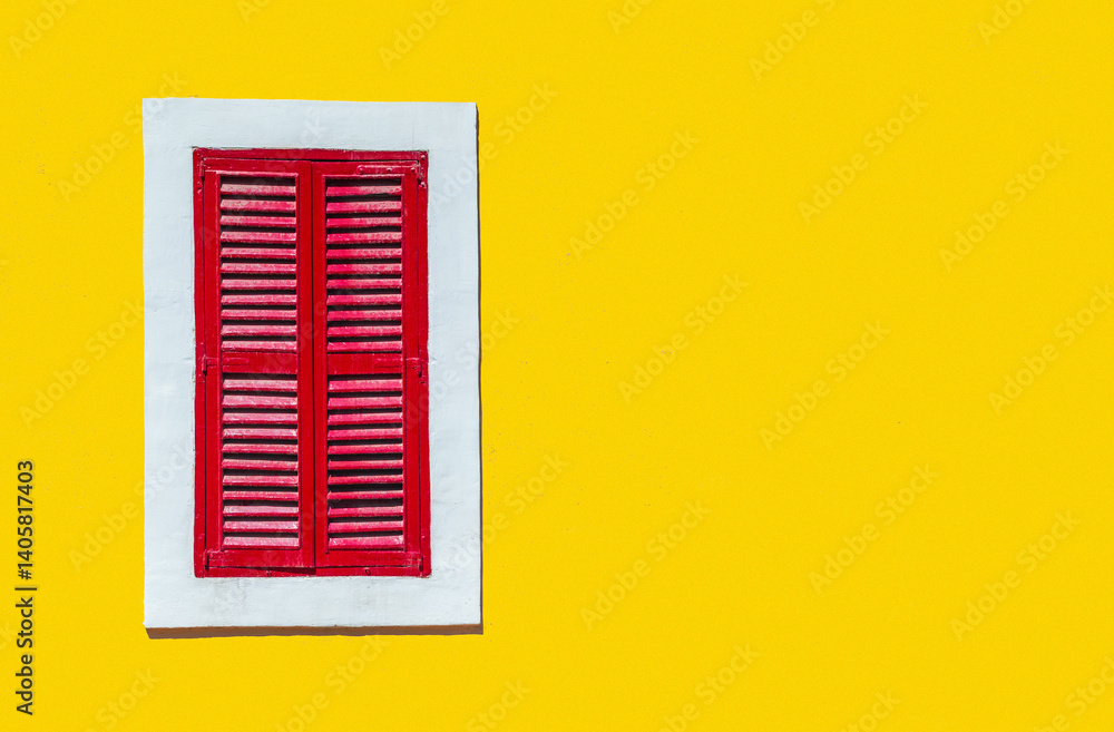 Minimalist style photo of yellow wall with red window in white frame, Murano, Venice, Italy