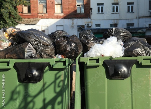 Plastic trash containers. A big, green trash cans for general household waste. Garbage equipment for household waste. Garbage cans for food waste and trash. Environmental situation and garbage in town