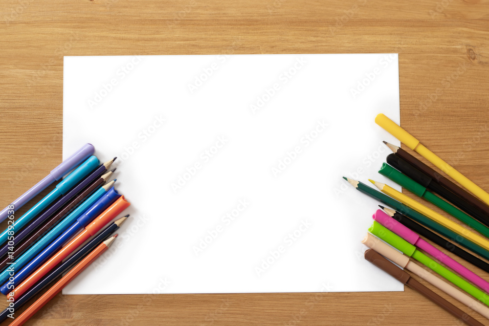 Obraz premium white sheet of paper on a wooden table, colored pencils. Children's creativity