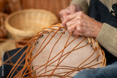 Konstfotografi artisan making wicker basket closeup hands in a traditional event party in Galicia
