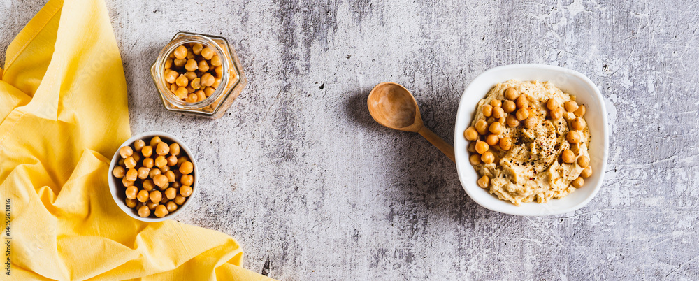 Vegetarian spicy chickpea hummus in a bowl on the table top view web banner