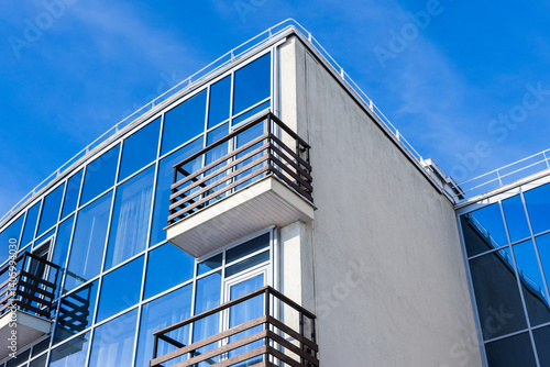Obraz na płótnie Corners of blue white glass building featuring wooden balconies w salonie