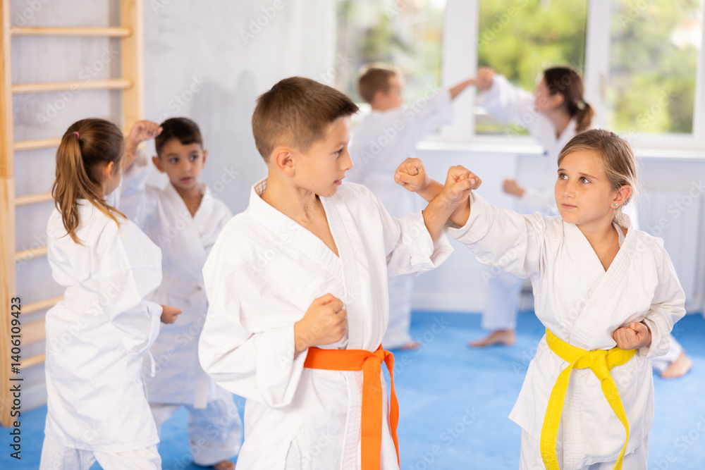 Children students athletes at Academy of martial Arts practice karate and fight opponents in pairs. Obtaining black belt, advanced training, highest dan of martial arts. Sport to max. Children students athletes at Academy of martial Arts practice karate and fight opponents in pairs. Obtaining black belt, advanced training, highest dan of martial arts. Sport to max.