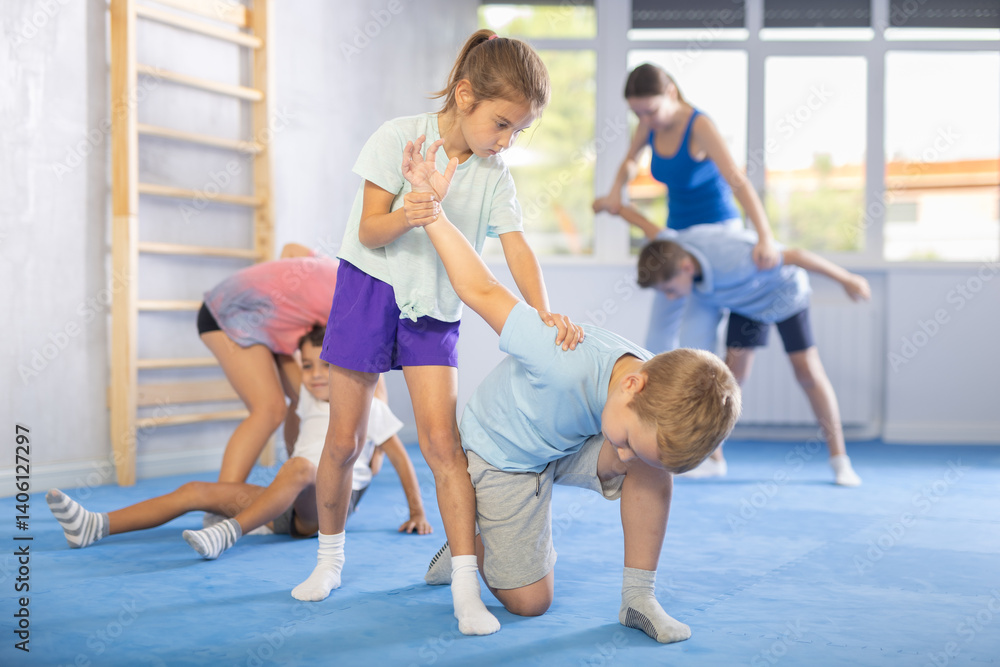 Obraz premium Boy and girl in gym perform basic elements of krav maga self-defense system. Preparation of athletes before competitions