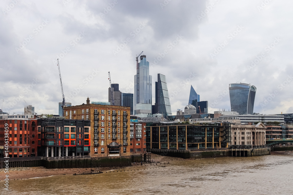 London, United Kingdom - 04. October 2024: London skyline with modern skyscrapers rising above Thames river under cloudy sky London, United Kingdom - 04. October 2024: London skyline with modern skyscrapers rising above Thames river under cloudy sky