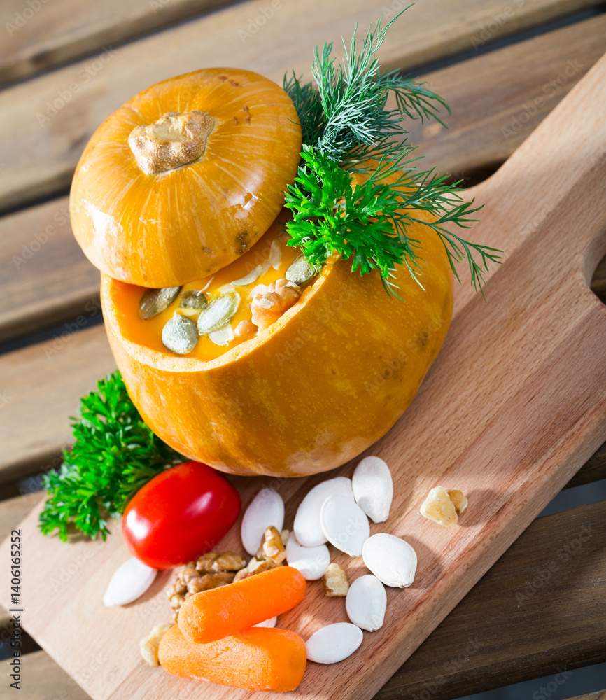 Image of Pumpkin soup. Cleaned pumpkin bake in oven. Take out pulp with spoon and mix in blender with olive oil, salt, pepper and greens. Serve in a baked pumpkin with fresh greens.