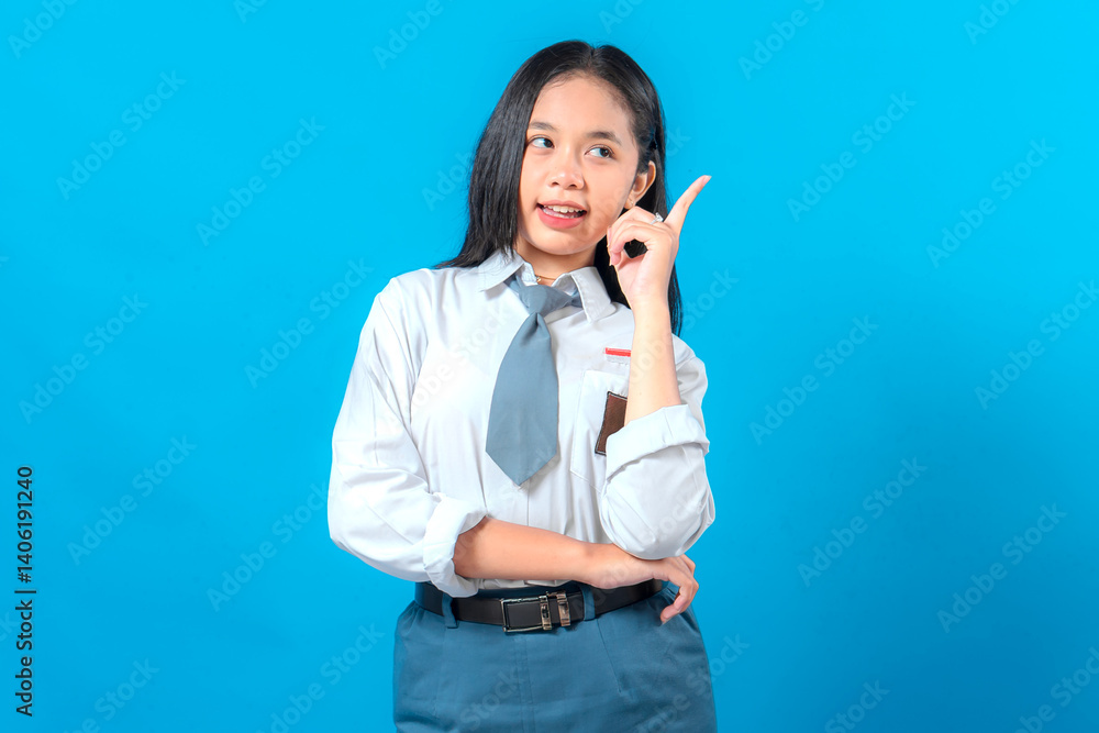 An Indonesian high school student in uniform poses with an inspired expression, pointing upward as if sharing an idea. Confident and cheerful look, perfect for educational ads. An Indonesian high school student in uniform poses with an inspired expression, pointing upward as if sharing an idea. Confident and cheerful look, perfect for educational ads.