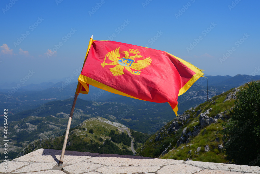 Montenegrin flag floating on top of Mount Lovćen near Cetinje in Montenegro