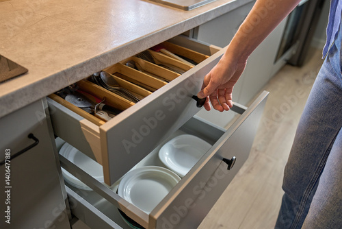 Obraz na płótnie Person opens a kitchen drawer with various utensils in wooden cutlery tray. Woman opening kitchen cabinet. Concept of home organization and functionality interior w salonie