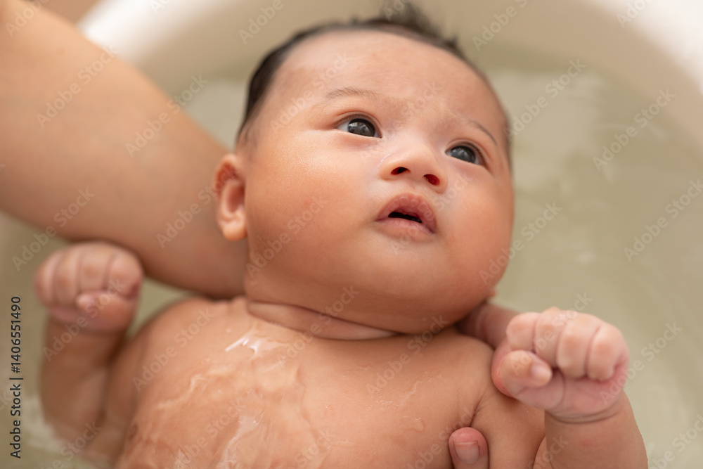Close up asian newborn baby bathing in bathtub. mother bathing her son in warm water. Happy adorable newborn infant smile in tub relax and comfortable good moment with mom. Newborn baby care concept Close up asian newborn baby bathing in bathtub. mother bathing her son in warm water. Happy adorable newborn infant smile in tub relax and comfortable good moment with mom. Newborn baby care concept