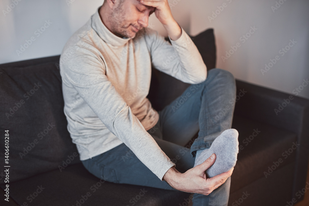 Man with ankle and foot pain at home.