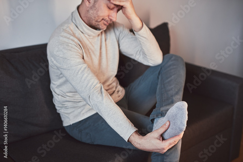 Obraz na płótnie Man with ankle and foot pain at home. w salonie
