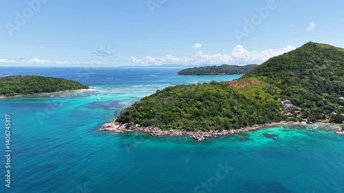 Praslin Island, Seychelles, with lush green hills, turquoise sea, and scenic tropical coastline under a clear blue sky.

