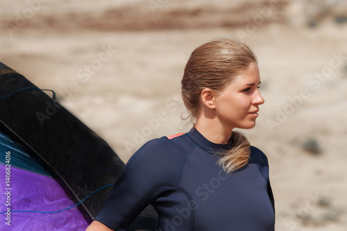 A woman with a multicolored parachute, an athlete riding kitersurfing on a blue pore. Beach, active recreation. Sunset competitions, parachute, board, freedom. High quality photo