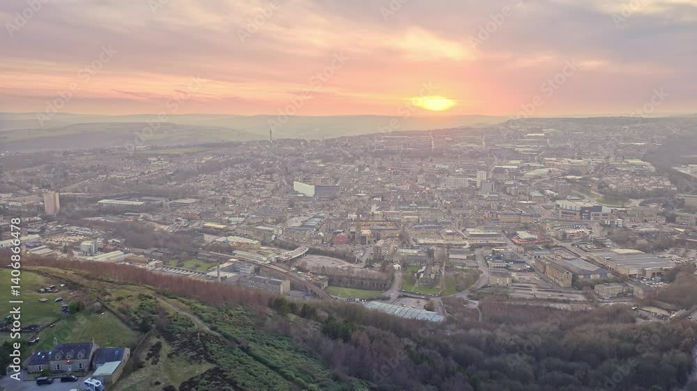 Establishing drone shot of Halifax cityscape from a hill at sunset with fire sky in West Yorkshire, England Establishing drone shot of Halifax cityscape from a hill at sunset with fire sky in West Yorkshire, England
