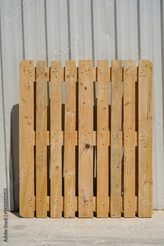 Wooden Pallet Leaning Against a Metal Wall in Industrial Setting